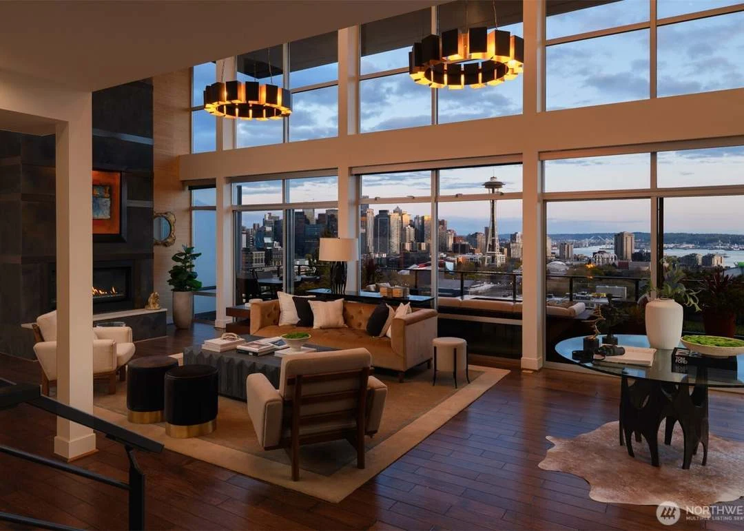Double-height living room overlooking the city at dusk